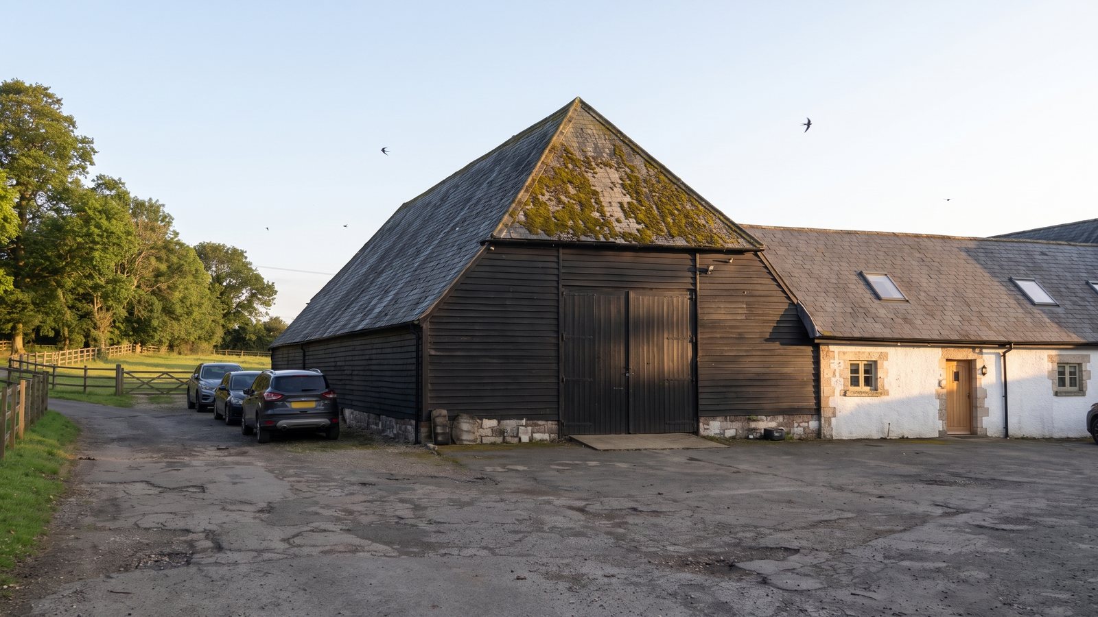 The black barn and the white office block on a summer evening